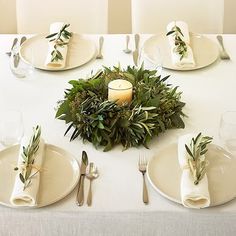 the table is set with white plates and silverware