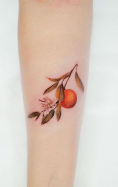 an orange tattoo on the left arm with leaves and flowers painted on it's side