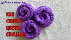 three crocheted purple flowers sitting on top of a white towel