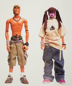 two dolls are standing next to each other in front of a white background and one is wearing shorts