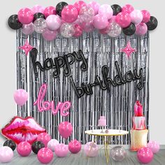 a birthday party with pink and black balloons