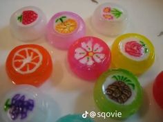 there are many different colored buttons on the counter top, including one with fruit and flower designs