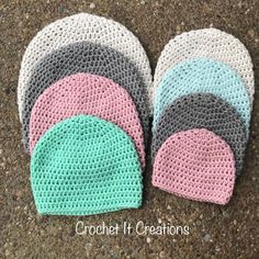 four crocheted hats sitting on the ground