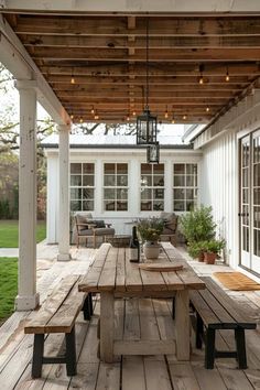 a wooden table sitting on top of a wooden floor next to a white building with lots of windows