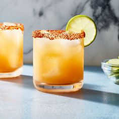 two margaritas sitting on top of a blue counter