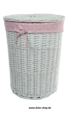 a white wicker basket with pink polka dots on the lid and ribbon tied around it