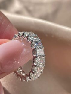 someone is holding a ring with diamonds on it