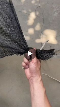 someone is holding an umbrella with some black netting on it and the bottom half has a white triangle