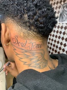 the back of a woman's head with a tattoo on her neck that reads soul free