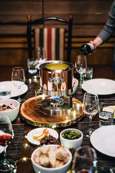 the table is set with dishes and wine glasses