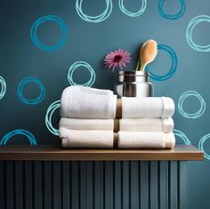 towels are stacked on top of each other in front of a blue wall with circles