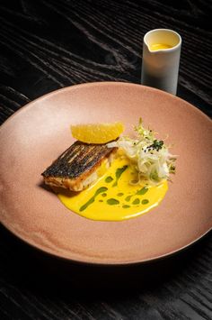 a plate with some food on it next to a glass of orange juice and a cup