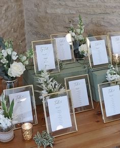 a table topped with lots of small vases filled with flowers and greenery next to each other