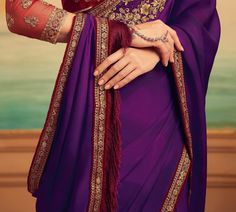 COLOR : Purple & Maroon FABRIC : Saree - Orange Silk, Blouse - Net & Orange Silk WORK : Resham Embroidery, Zari Work, Fringe Tassels, Sequins, Beads, Stones & Lace BorderOCCASION : Wedding, Engagement, Party Wear, Festival, Sangeet READY-TO-WEAR : No STITCHING : Available as semi-stitched fabric, can be stitched using standard size option (+$20). Note: There might be a slight color variation due to lighting and flash used during photoshoot. The bright shade seen is the best closer view of fabric Floor-length Lehenga With Embroidered Border, Purple Embroidered Fabric For Eid, Elegant Purple Sets With Embroidered Border, Purple Traditional Wear With Embroidered Border, Purple Traditional Drape With Embroidered Border, Wedding Dresses With Embroidered Border In Art Silk, Floor-length Traditional Wear With Embroidered Border For Diwali, Festive Purple Saree With Embroidered Border, Purple Dupatta With Embroidered Border In Traditional Drape