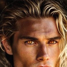 a man with long blonde hair and orange eyes