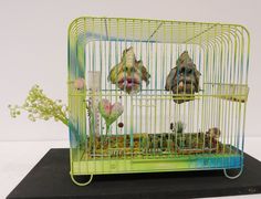 three birds in a green cage with flowers