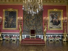 an ornate room with paintings and chandeliers