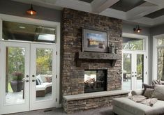 a living room filled with furniture and a fire place in front of a stone fireplace