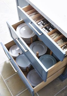 an open cabinet with plates and bowls in it