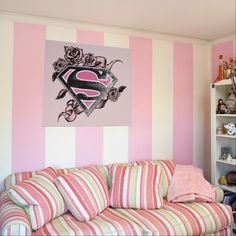 a pink and white striped room with a couch, bookshelf, and shelves