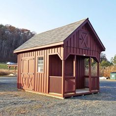 a small red shed sitting on top of a gravel field