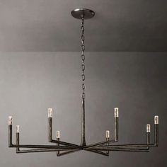 a chandelier hanging from the ceiling in a room with gray walls and flooring