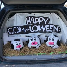 three cow heads in the back of a car with happy halloween written on it's side