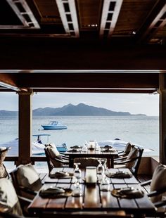 an outdoor dining area overlooking the water with boats in the distance