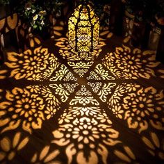 the shadow of a stained glass window on a wooden floor in front of a tree