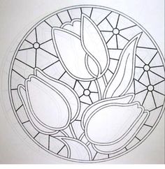 a circular stained glass window with flowers in the center and leaves on it's side