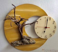 a clock that is on the wall next to a tree and a piece of driftwood