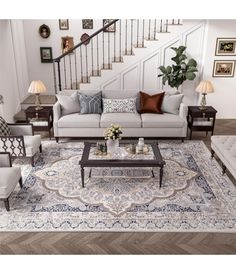 a living room filled with furniture and a stair case in front of the couches