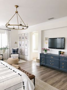 a bedroom with a bed, dresser and tv in it's centerpieces