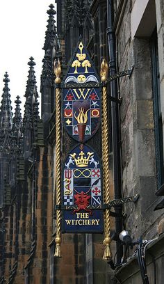 a clock on the side of a building with ornate designs and gold trimmings