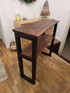 a wooden table sitting on top of a hard wood floor next to a christmas tree