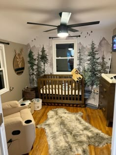 a baby's room with a crib, rocking chair, and television in it