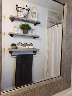 a bathroom mirror with some shelves above it