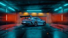 a grey sports car parked in a parking garage with its door open and lights on