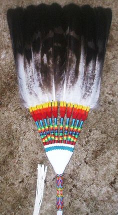 several feathers are arranged on the floor with tassels in front of them,