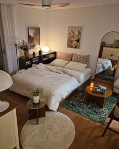 a bed sitting in the middle of a living room next to a dresser and mirror