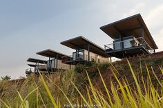 three modern houses on the side of a hill