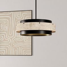 a light fixture hanging from the ceiling in front of a wall with an abstract design