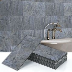 a stack of gray marble tiles next to a sink