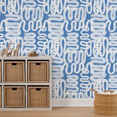 a blue and white wallpaper with some baskets on the floor in front of it