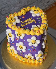 there is a purple cake with yellow and white decorations on it