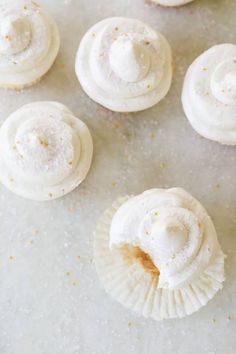 white frosted cupcakes with icing and sprinkles