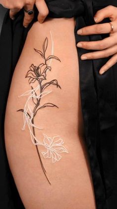 a woman's thigh with a flower tattoo on it