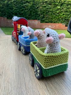 three small crocheted animals riding in a toy train