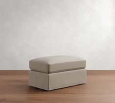 a small foot stool sitting on top of a wooden floor next to a white wall