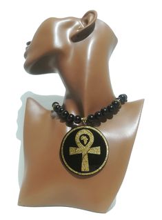 This handmade black and gold Afrocentric 2 - sided necklace carries 2 symbols from ancient Kemet. The Ankh represents eternal life. It is sometimes referred to as the "Key of Life". It is also associated with the balance between masculinity and femininity. The Eye of Ra has been commonly associated with the following: protection, Fertility, Birth, femininity, the sun, good luck, strength, power, destruction, and fury.  All Jewelry items produced by Afrocentric Art Store are authentically handmad Black Spiritual Medallion Jewelry, Black Brass Spiritual Jewelry, Symbolic Black Medallion Necklace, Spiritual Black Medallion Jewelry, Black Ankh Jewelry For Gifts, Black Symbolic Medallion Jewelry, Black Ankh Spiritual Jewelry, Symbolic Black Brass Necklace, Black Brass Medallion Jewelry